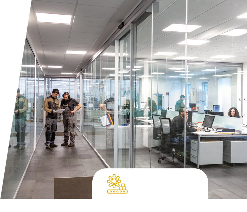 Technical and administrative offices of Eredi Baitelli, with floor-to-ceiling windows and staff working in a bright and transparent environment.