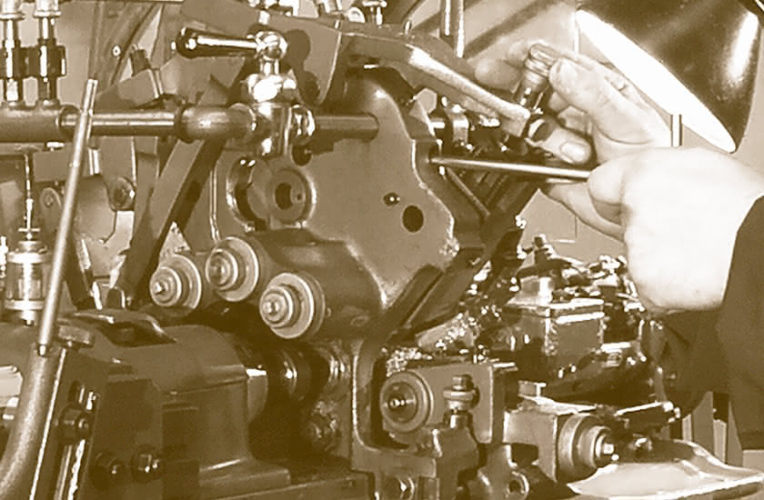 Skilled hands at work on a vintage mechanical lathe, symbol of the origins of Eredi Baitelli in 1945.