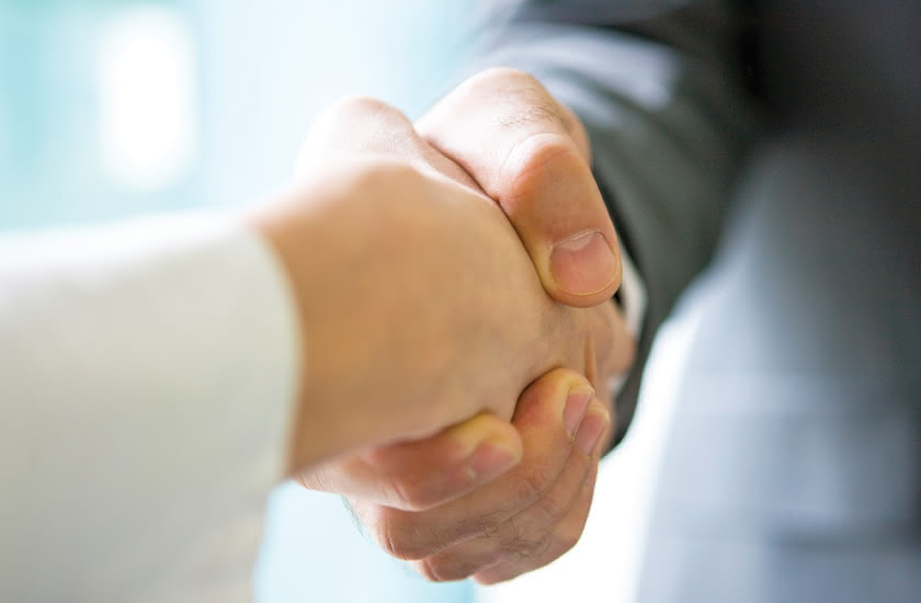 Handshake between two people, symbolizing the merger between Eredi Baitelli and Minuterie Eredi Baitelli.