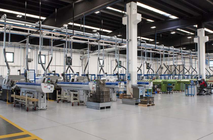 Inside the new Eredi Baitelli production site in Erbusco, with neat rows of automatic lathes and extraction systems.